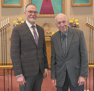 Two men in suits are standing in front of a church.

AI generated content