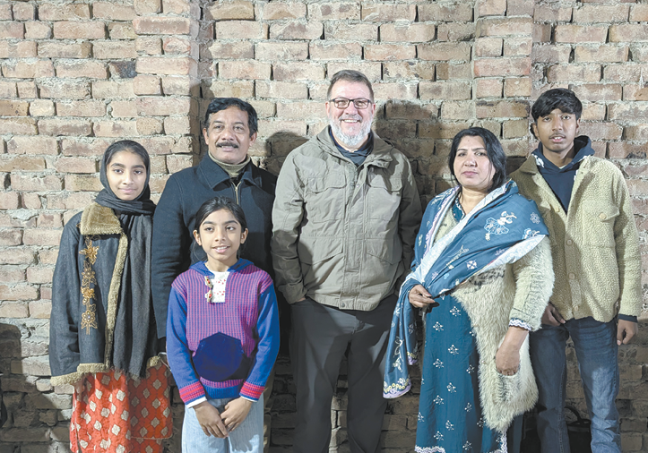 A group of people, including a man and a woman, pose for a picture in front of a brick wall.

AI generated content