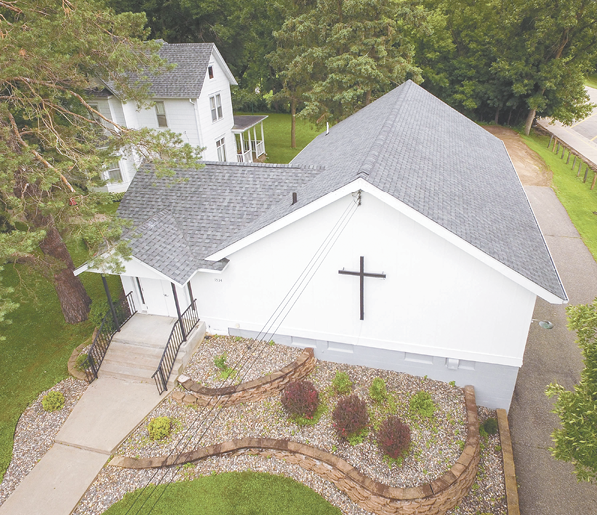 A white church with a cross on top of it.

AI generated content